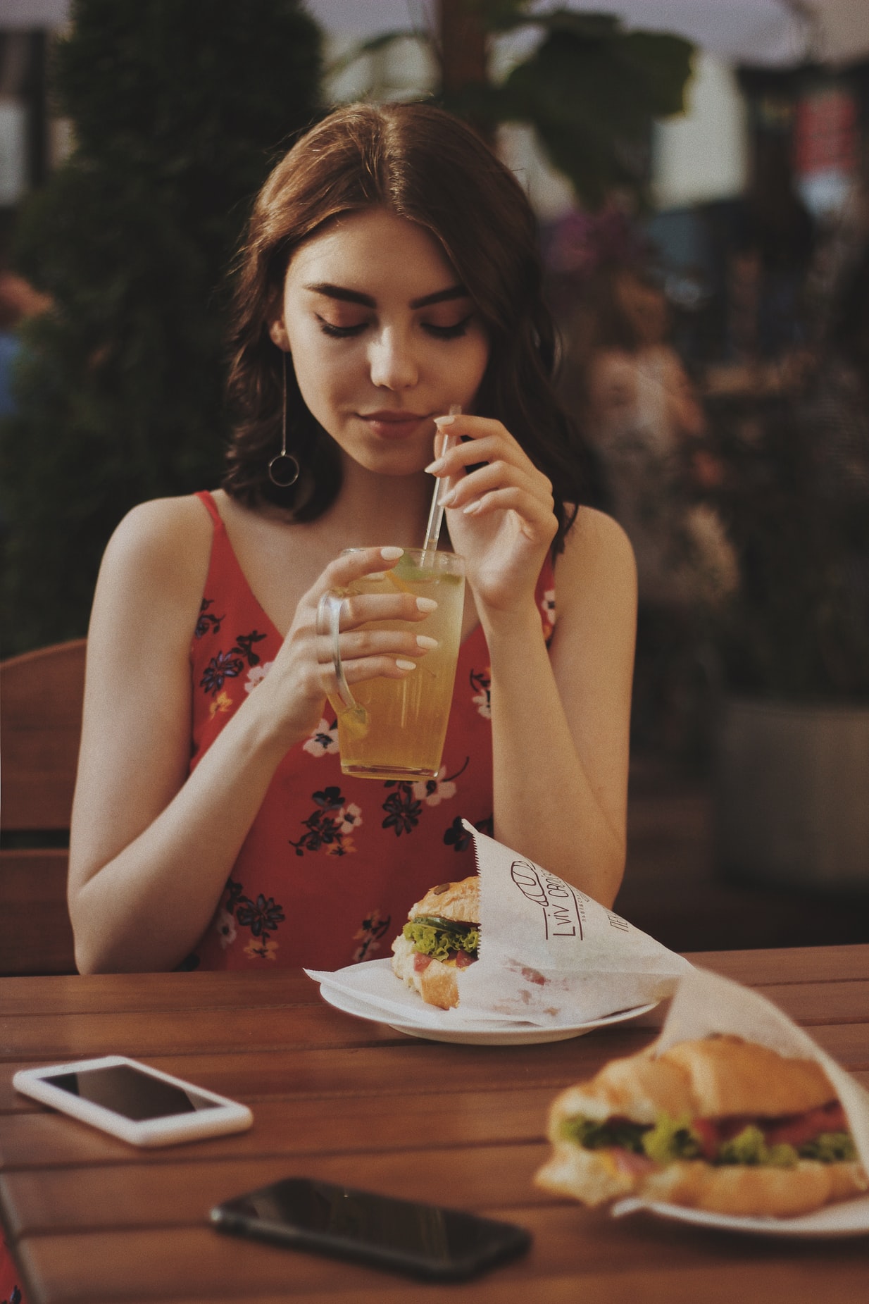 A women eating her meal and drinking cold-drink in a resturant